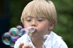 child blowing bubbles